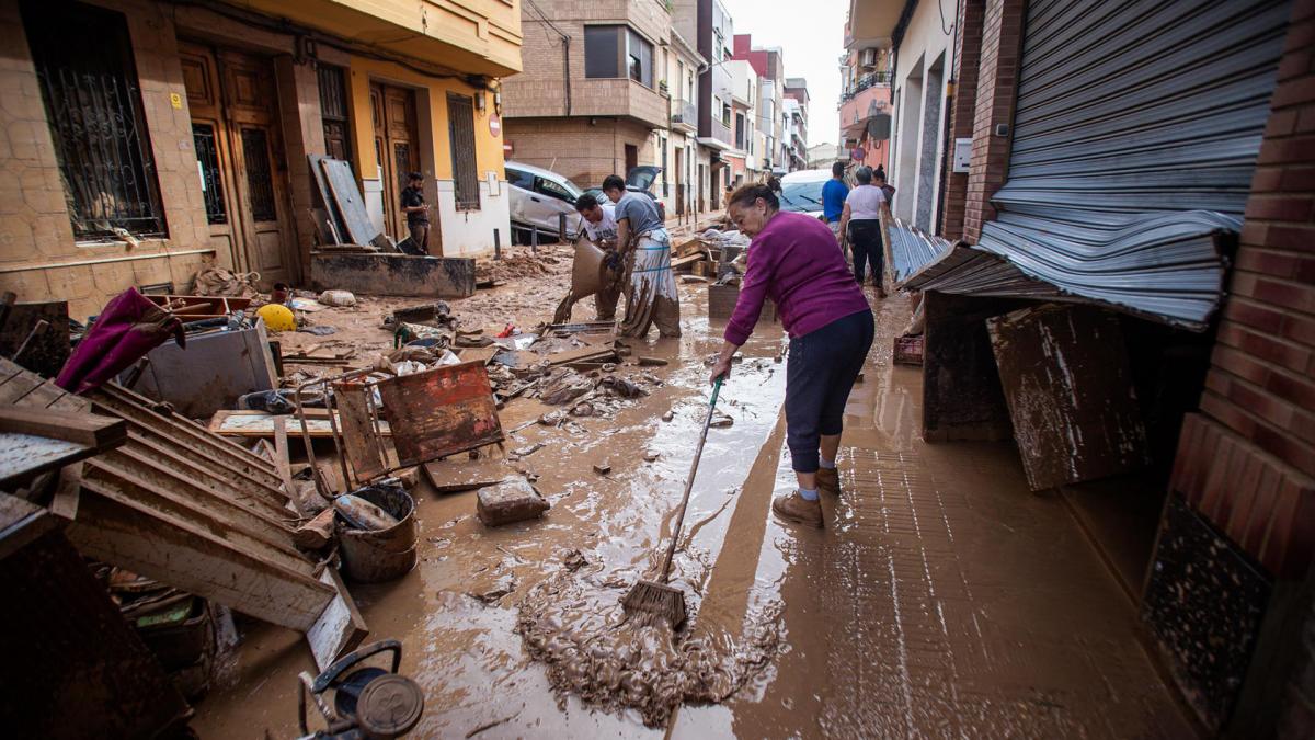 Una mujer lucha contra el barro tras la DANA de Valencia. TANIA CASTRO.